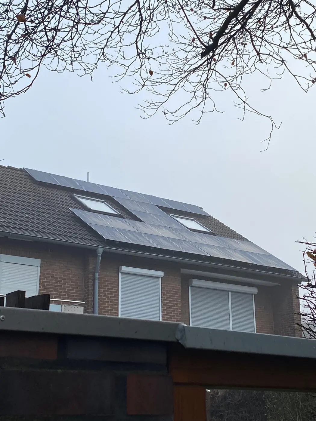 Photovoltaikanlage auf dem Dach eines Klinkerhauses mit zwei Dachfenstern